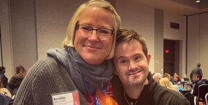 Volunteer, Kristin Schoonveld, smiling and embracing a Special Olympics of Indiana Athlete.