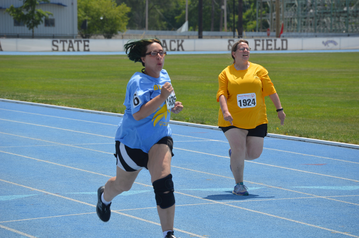 Two female athletes running on track