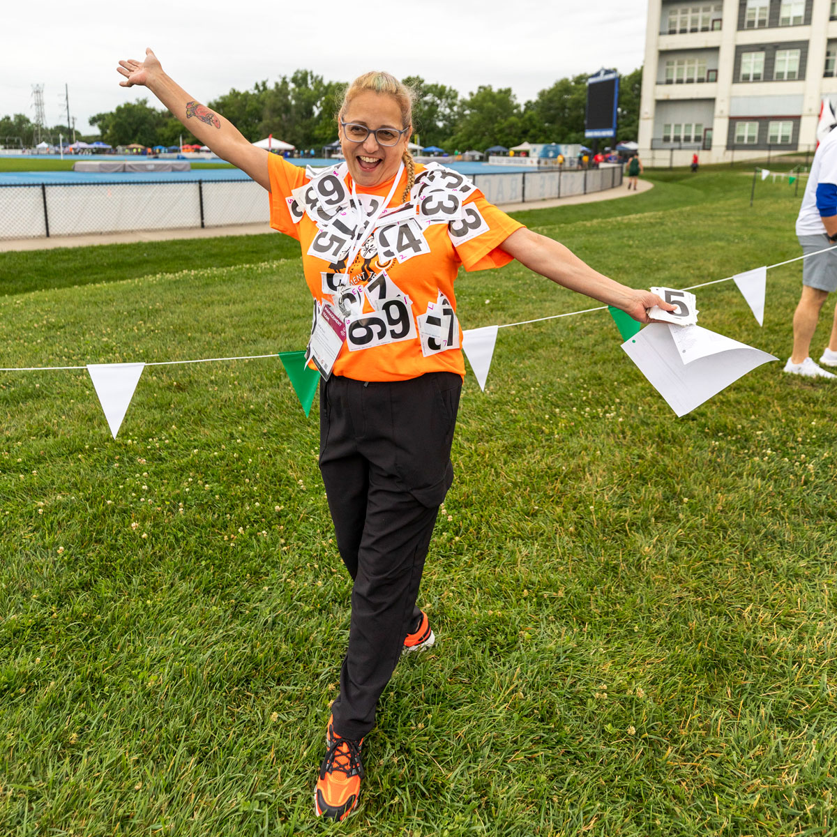 Woman in orange shirt with numbers all over it.