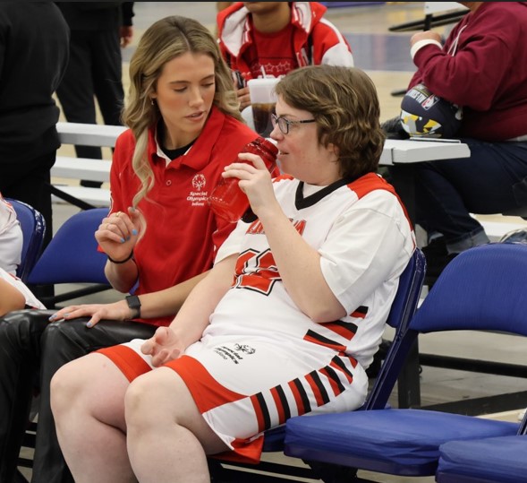 Indiana Fever player Lexi Hull coaching a player on the bench of a basketball game. 