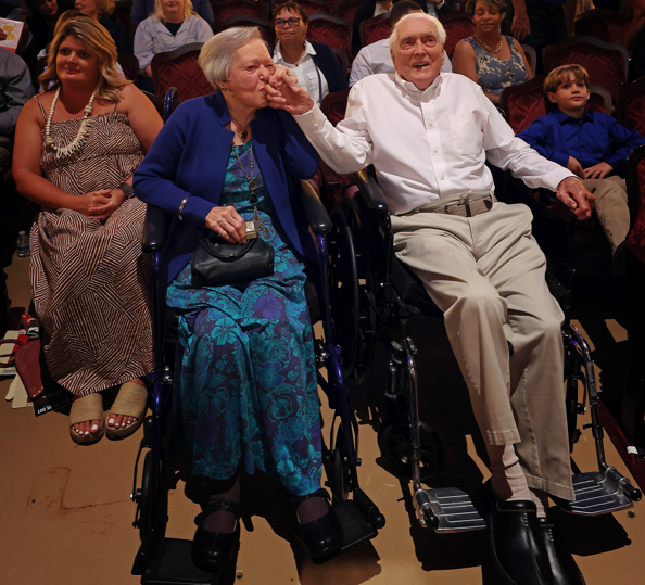 Carl Erskine in wheel chair next to woman kissing his hand