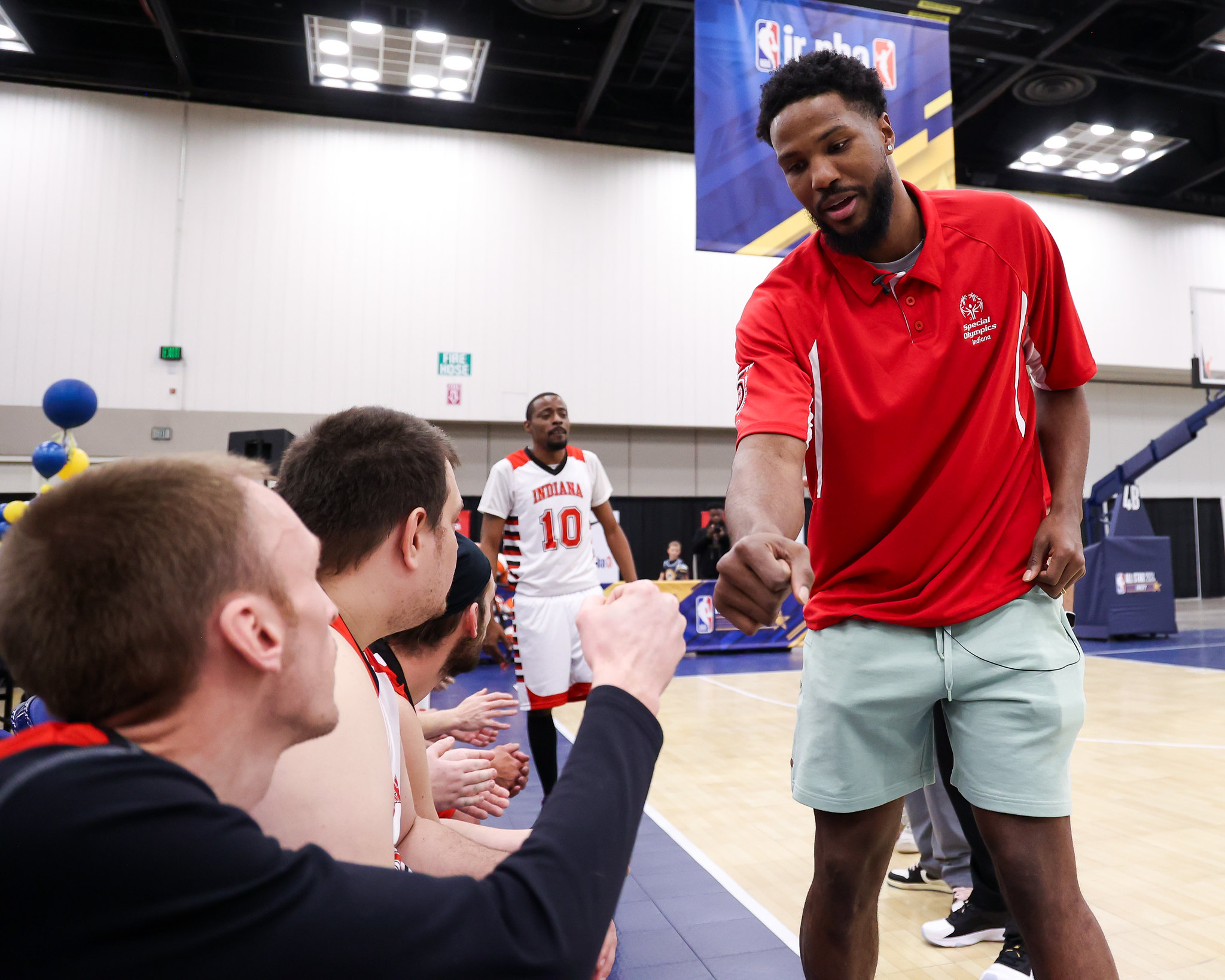 Special Olympics coach fist bumping athletes