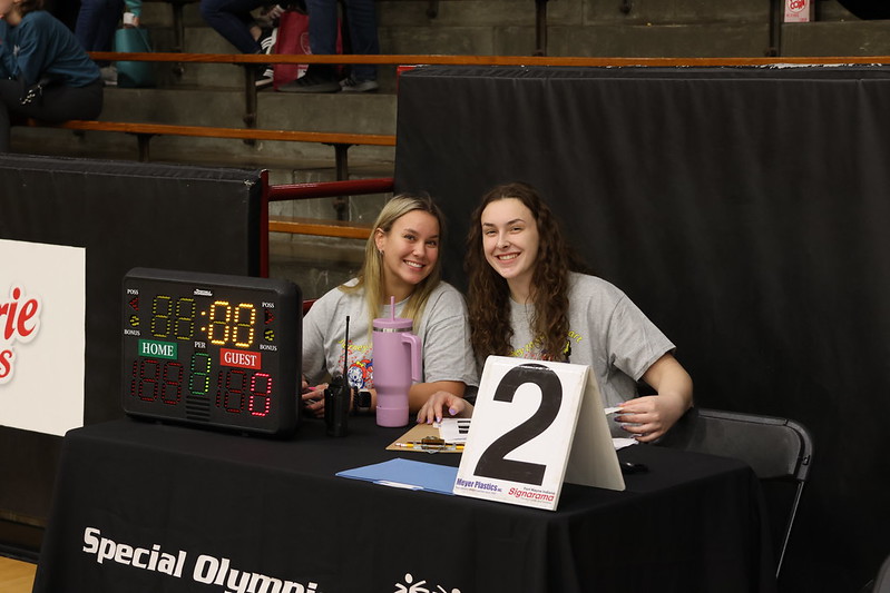 2 volunteers sitting at a timekeeping table