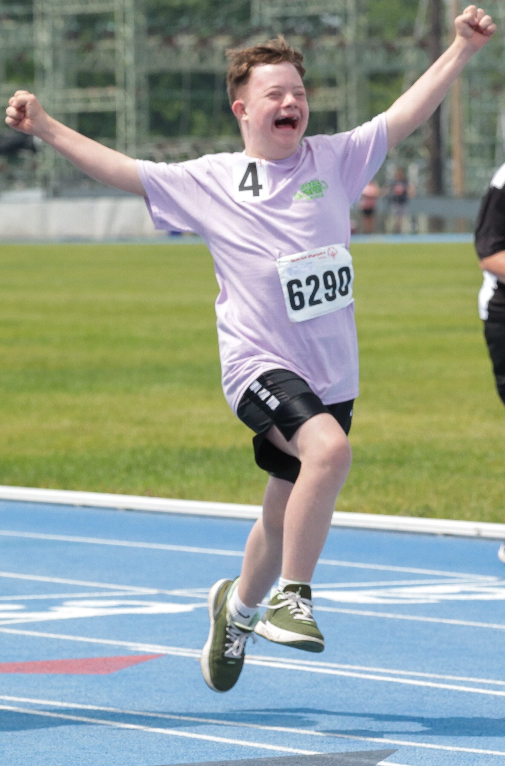 A Special Olympics Athlete cheers after finishing a race at Summer Games.